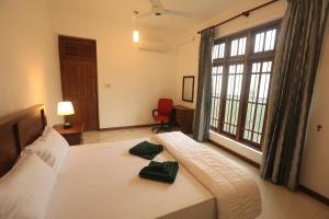 - une chambre avec un lit et 2 serviettes vertes dans l'établissement King's Court Kandy, à Kandy