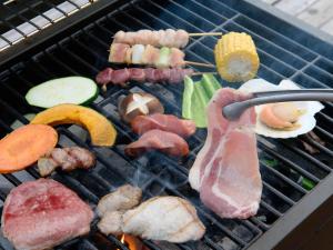 a bunch of meat and vegetables on a grill at Godere hotel Fujisanakako Tabist in Yamanakako