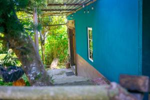 an open door of a blue house with a porch at Las Cabañitas, el boqueron in San Salvador