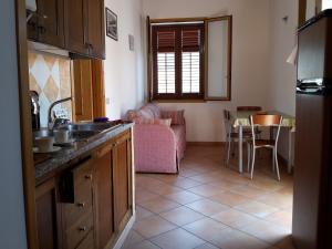 a kitchen and living room with a couch and a table at UsticaTour Apartments and Villas in Ustica