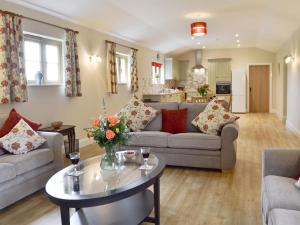 un salon avec un canapé et une table dans l'établissement Woodlands Dairy Cottage, à Billingshurst