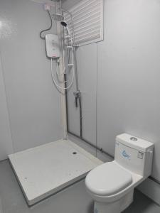 Un baño con inodoro blanco y ducha. en Tekoma Resort Taman Negara, en Kuala Tahan