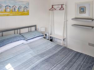 a bedroom with a bed and a painting on the wall at Sandy Cott in Kilkhampton