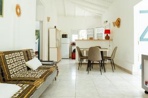 a kitchen and dining room with a table and chairs at Kaz a ti Piéwo in Les Abymes
