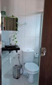a bathroom with a toilet and a sink and a mirror at Casa Carauarí in Alter do Chao