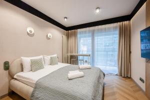a bedroom with a bed and a large window at LILY APART - Foodhall & Rooftop Terrace in Gdańsk