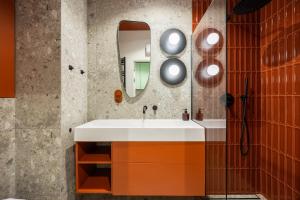 a bathroom with a sink and a mirror at LILY APART - Foodhall & Rooftop Terrace in Gdańsk