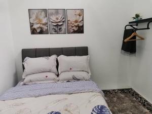 a bedroom with a bed with four pillows at Maldira Homestay in Batu Gajah in Gua Sai +1 photo