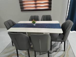 a white table with chairs and a potted plant on it at Maldira Homestay in Batu Gajah in Gua Sai