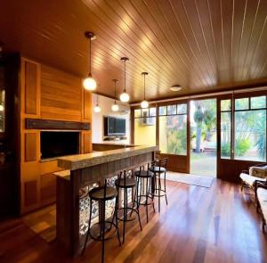 a living room with a bar with stools and a fireplace at Ampla e luxuosa casa com áreas de lazer in Pelotas