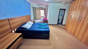 a bedroom with a blue bed and wooden cabinets at Ampla e luxuosa casa com áreas de lazer in Pelotas