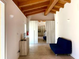 a living room with a blue chair and wooden ceilings at My House in Monsampietro Morico