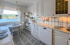 a kitchen with white cabinets and a table and a window at 3 Bedroom Amazing Home In Farsund in Farsund
