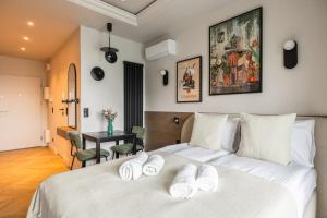 a bedroom with a white bed with white towels on it at LILY APART - Foodhall & Rooftop Terrace in Gdańsk