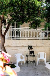 two white chairs and a table and a tree at Thomy's Apartment in Nea Michaniona in Nea Michaniona