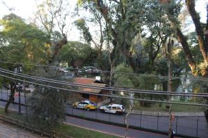 two cars parked on a street with trees at Casa do Estudante Luterano Universitário - CELU in Curitiba