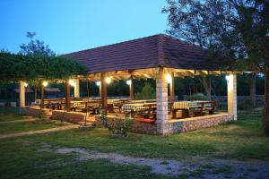 Agrotourism Galic Krka في Drinovci: جناح بطاولات ومقاعد في حديقة في الليل