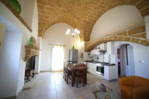 a kitchen and dining room with a table and chairs at La Corte Delle Sterne in Morciano di Leuca