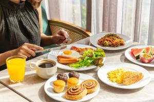 a table with plates of breakfast food on it at Staybridge Suites Bangkok Thonglor by IHG in Bangkok
