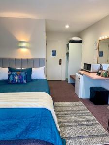a hotel room with a bed and a kitchen at Heritage Park Lodge in Haast