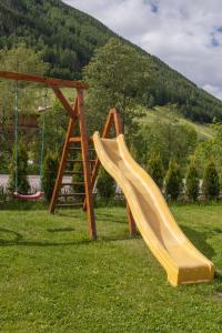 a yellow slide on a playground in a field at Ferienwohnung & Spa Access Zimmerhofer in Cadipietra