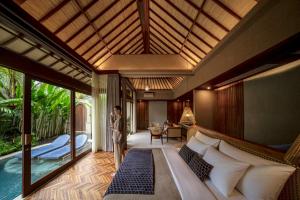 Asvara Resort & Spa Ubud by Ini Vie Hospitality في أوبود: غرفة نوم مع سرير في غرفة مع مسبح