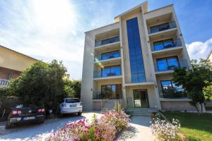 a building with cars parked in front of it at Apartments Matkovic Lux in Sutomore