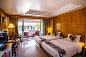 a hotel room with two beds and a television at Phi Phi Banyan Villa in Phi Phi Don