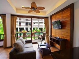 a living room with a couch and a flat screen tv at Maryoo Samui Hotel in Chaweng