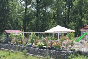 a garden with flowers and an umbrella at Katie in Tianeti in Zhebota