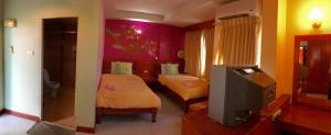 a bedroom with two beds and a tv in it at Loei Orchid Hotel in Loei