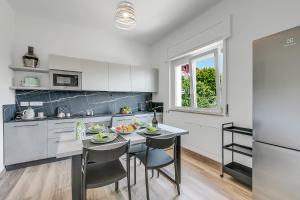 Una cocina con una mesa y sillas en una cocina. en Casa Tramonti - Happy Rentals, en Gemonio