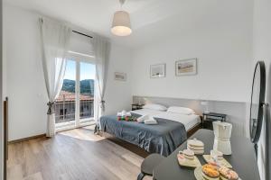 Un dormitorio blanco con una cama y un balcón. en Casa Tramonti - Happy Rentals, en Gemonio
