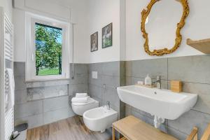Un baño con lavabo, inodoro y espejo. en Casa Tramonti - Happy Rentals, en Gemonio 25 fotos más