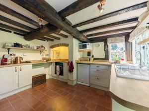una cucina con armadietti bianchi e pavimento piastrellato di Manor Cottage a Eckington