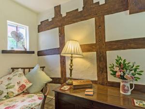 una stanza con un letto e un tavolo con una lampada di Manor Cottage a Eckington