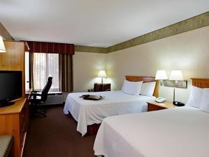 a hotel room with two beds and a flat screen tv at Flagstaff Hotel in Flagstaff