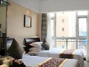 a hotel room with two beds and a large window at Best Western Tianjin Juchuan Hotel in Binhai +35 photos