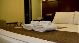 a pile of towels sitting on top of a bed at The Grande Suites in Surigao +3 photos