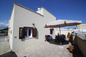 a patio with a table and an umbrella at La Corte Delle Sterne in Morciano di Leuca