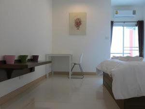 a bedroom with a bed and a desk and a window at The Passion Hotel in Chiang Mai