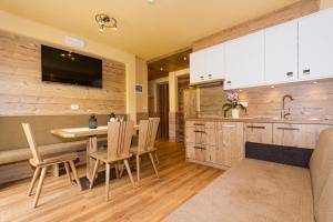 a kitchen and dining room with a table and chairs at Ferienwohnung & Spa Access Zimmerhofer in Cadipietra +16 photos