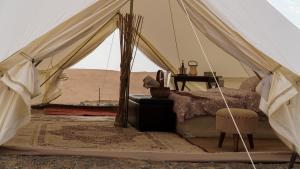 a room with a tent with a bed and a table at The One - Sunrise private Tent camp in Bidiyah
