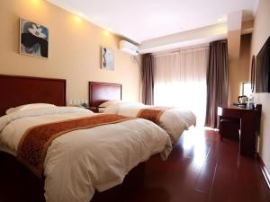 a hotel room with two beds and a window at GreenTree Inn Shandong Yuncheng Ximen Street Songjiang Kung Fu School Business Hotel in Yuncheng +56 photos