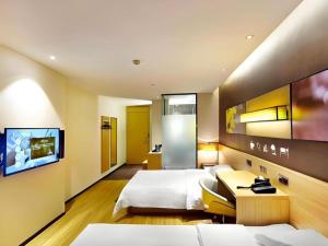 a hotel room with two beds and a tv at IU Hotel Baoding Goverment Shidai in Baoding +148 photos