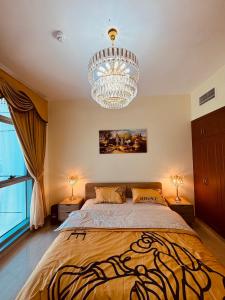 a bedroom with a large bed and a chandelier at sea view luxurious holiday homes in Ajman 