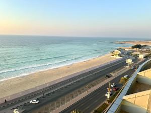 a road next to the ocean with a beach at sea view luxurious holiday homes in Ajman 