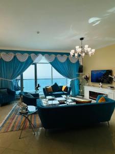 a living room with a large blue couch and blue curtains at sea view luxurious holiday homes in Ajman 