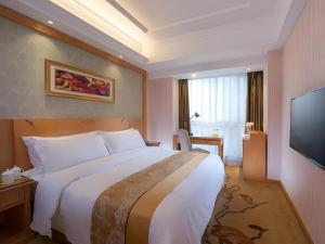 a bedroom with a large bed and a flat screen tv at Vienna Hotel Chengdu Chunxi Road Lijiatuo Metro Station in Chengdu