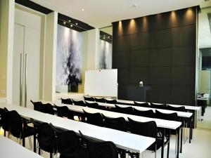 a lecture hall with white tables and black chairs at Jinjiang Inn Select Xuzhou Suning Plaza Jinguang East Road in Xuzhou